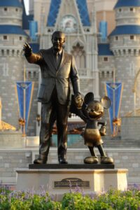 Walt Disney standing with Mickey Mouse