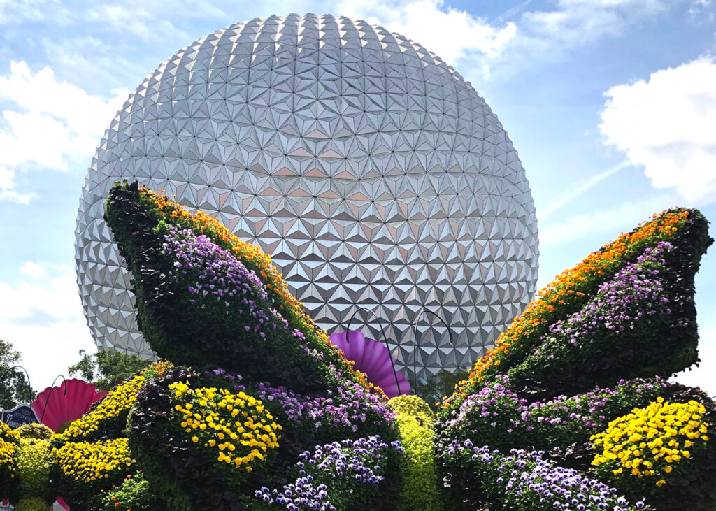 Exterior photo of Spaceship Earth with butterfly topiary