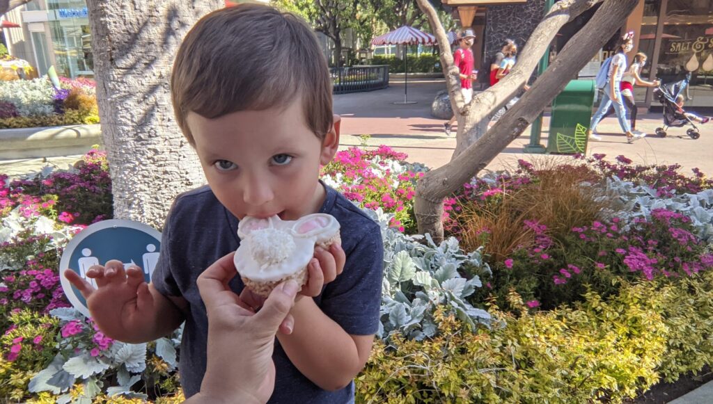 Lincoln dando un mordisco a la golosina Rice Krispy de conejito de Pascua en Downtown Disney