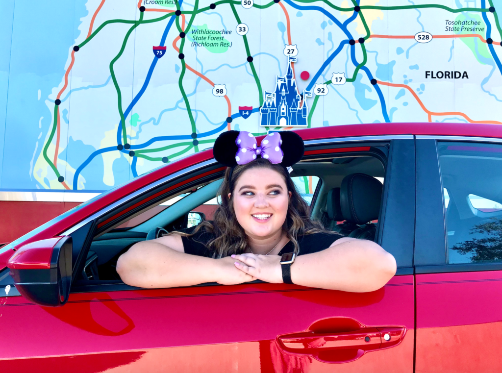 Girl traveling to Disney World in red car