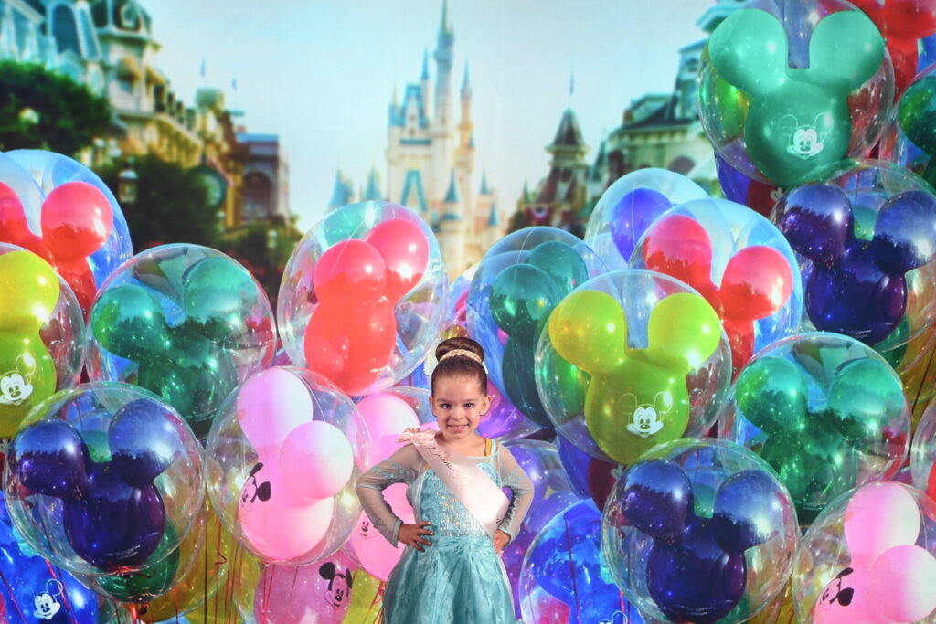 Chica en traje de princesa con telón de fondo de Disney World