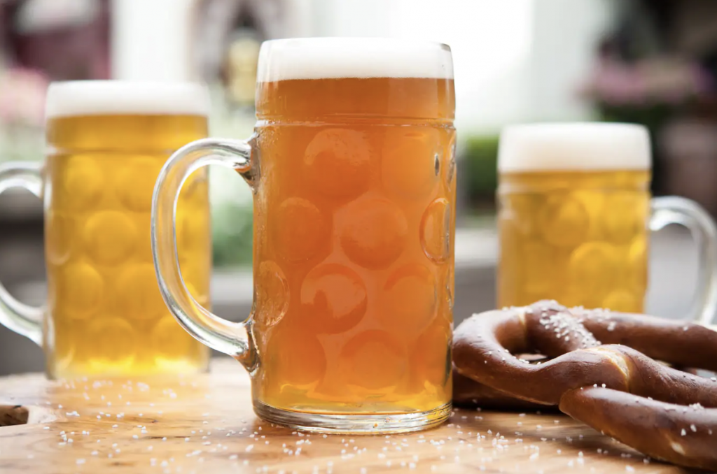 Photo of beers in mugs and pretzel. 