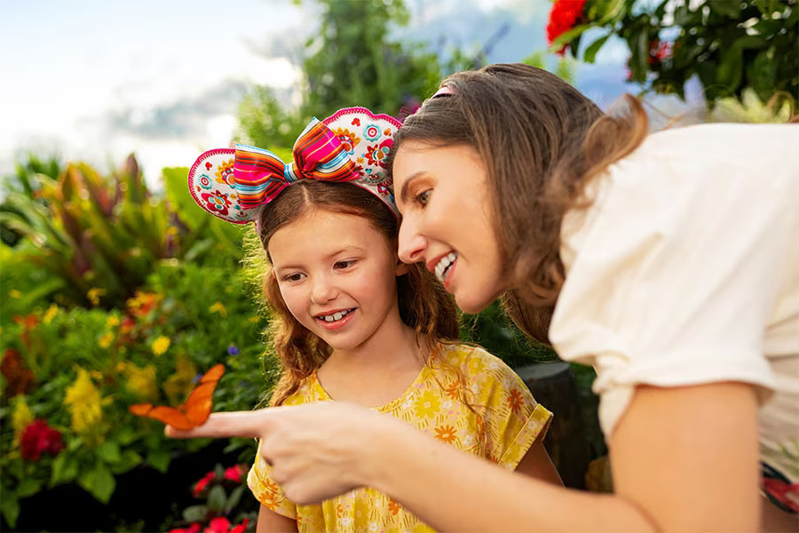 Mother and daughter with a butterfly in the Butterfly Landing Presented by AdventHealth during the EPCOT International Flower & Garden Festival